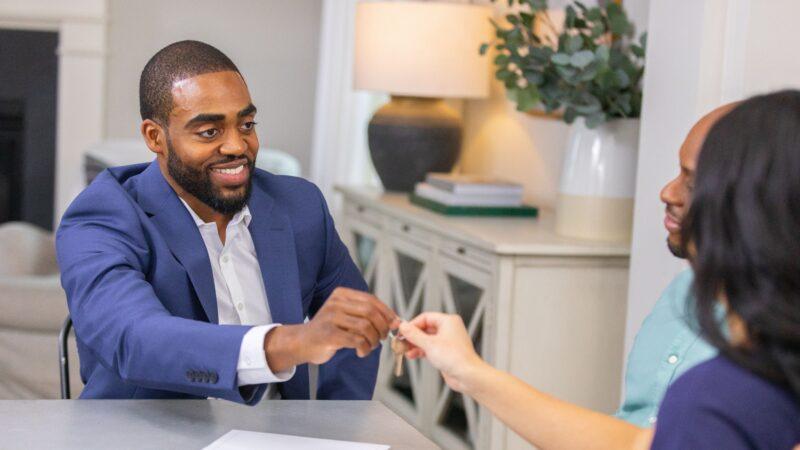 agent handing over keys at a table - our guaranteed offer