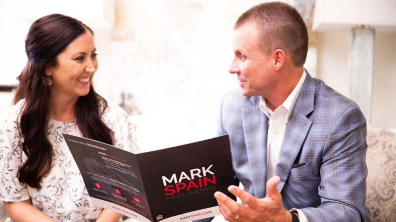 Mark Spain consulting with a Dallas real estate client in finding the right selling program for her and her family