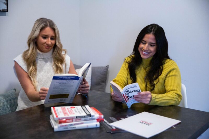 Two coworkers reading for personal growth at Mark Spain Real Estate